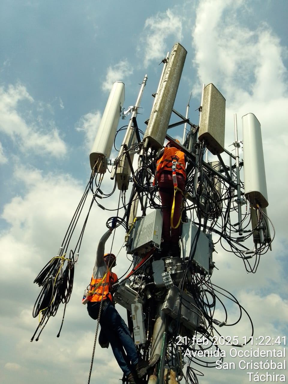 Técnicos de MT.NET con arnés de seguridad realizando mantenimiento en torre